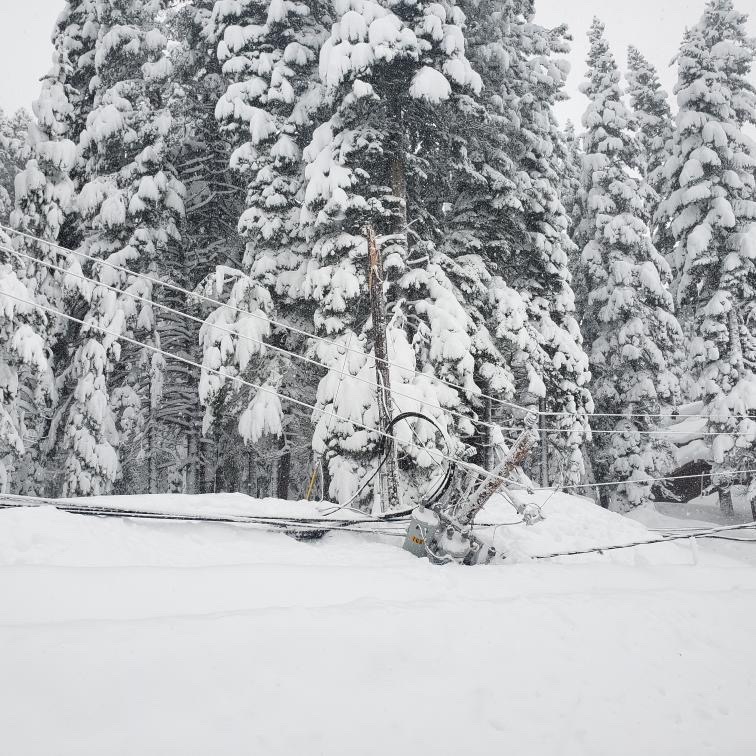 Damaged power pole laying in snow during December 2021 mega storm