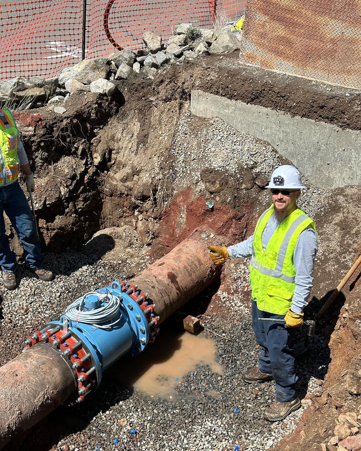 tdpud water worker giving thumbs up next to water pipeline