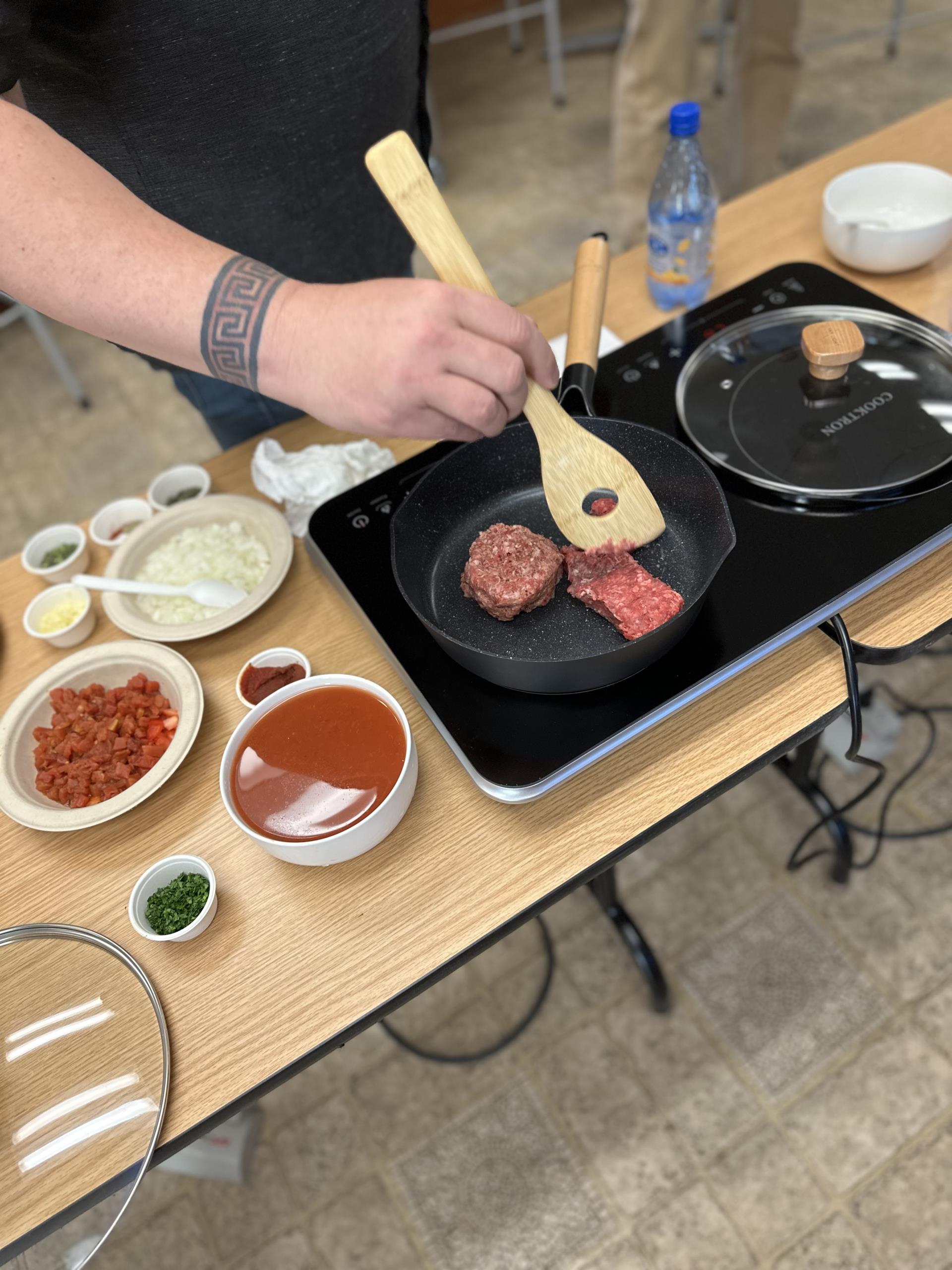 a birds eye view look at all the ingredient on the table and a person cooking at TDPUDs induction cooking class